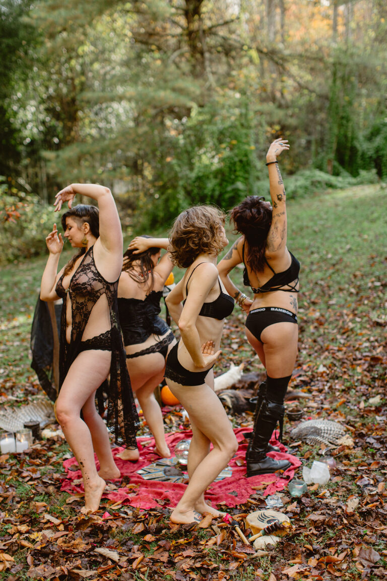Women dance together on the grass while wearing lingerie during a boudoir party